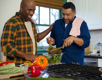Two People Preparing a Salad Together in a Kitchen