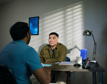 Two People Talking While Seated Across a Desk