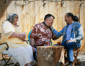 Three People Sitting Outside, Having Drinks